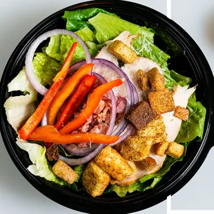 ROMAINE CALM Chicken, freshly grated parmesan cheese, bacon, red onion, and red pepper. Topped with croutons.