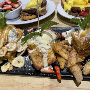 a plate of waffles with bananas and strawberries