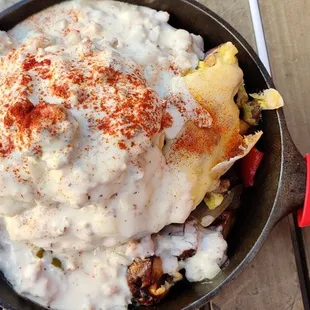 a skillet of food on a wooden table