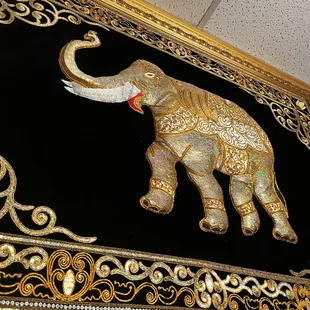 a gold elephant on a black background