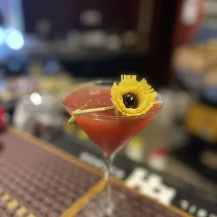 a yellow flower in a martini glass