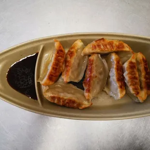 a plate of dumplings and sauce