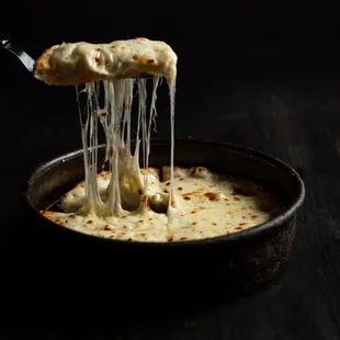 a piece of cheese being lifted by a fork
