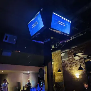 two televisions above a bar