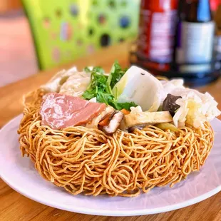 a plate of noodles with meat and vegetables