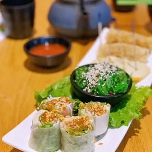 a plate of sushi rolls and a bowl of dipping sauce
