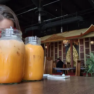 a woman looking at two jars of juice