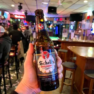a person holding a bottle of beer