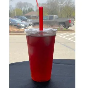 a red drink in a plastic cup with a straw