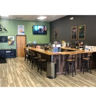 a bar with stools and a television