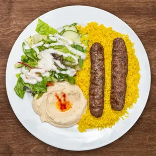 a plate of food with two sausages and a salad
