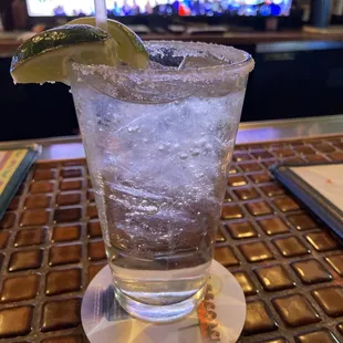 a glass of water with ice and lime garnish