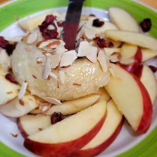Brie wrapped in puff pastry oven roasted topped with honey, almonds, cruising served with apple slices