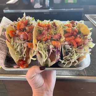a hand holding a taco