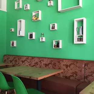 a booth with a table and green chairs