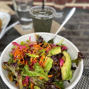 a bowl of salad and a drink