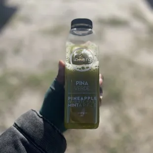 a person holding a bottle of pineapple juice