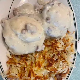 a plate of food with gravy and hash browns