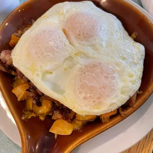two fried eggs in a wooden spoon
