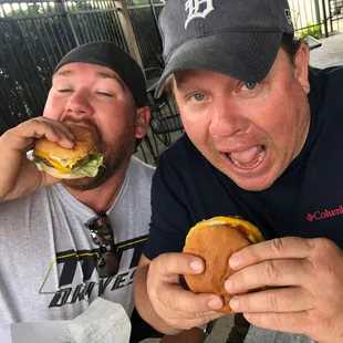 two men eating a hamburger