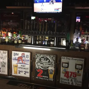 a bar with beer bottles and a television