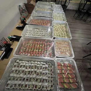 a long table with trays of sushi
