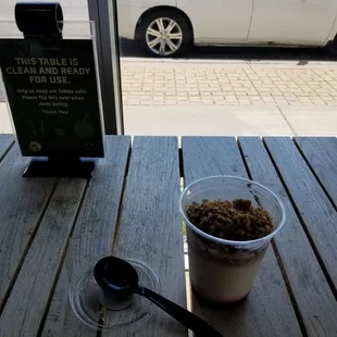 a cup of yogurt and a spoon on a table