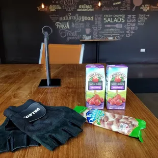 a table with a pair of gloves and a bag of fruit