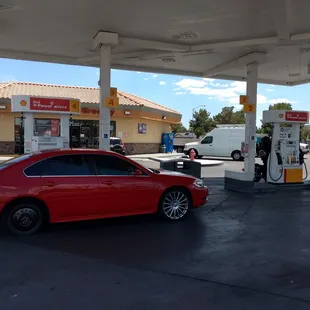 a red car at a gas station