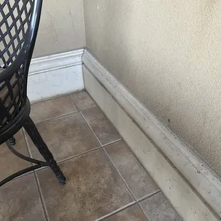 Very dirty walls and floor boards in balcony area