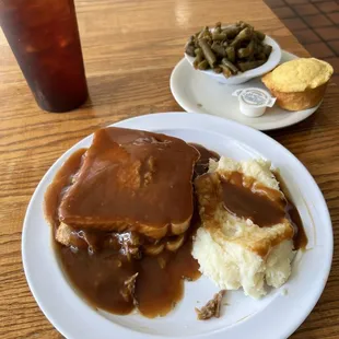 Roast with brown gravy, mashed potatoes, green beans, cornbread