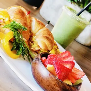 a croissant sandwich with strawberries and oranges