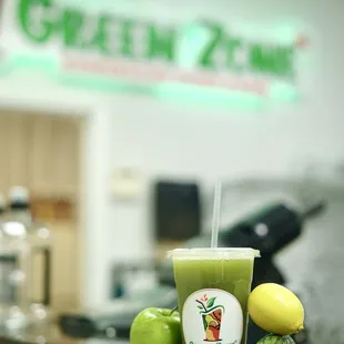 a cup of green juice on a counter