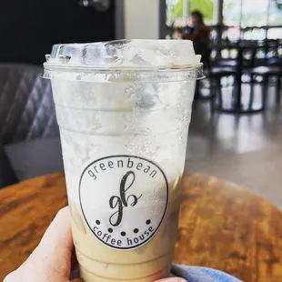a hand holding a cup of iced coffee