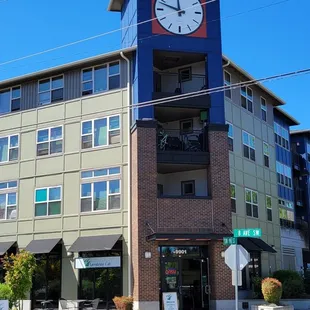 a clock tower on the corner of a street