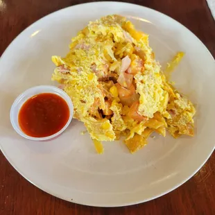 Migas Con Jamon (caramelized onions, tomatoes, roasted corn, jack cheese, ham, scrambled eggs, crispy tortillas, and avocado crema).