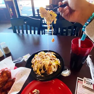 a person holding a fork over a plate of food