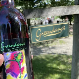 a hand holding a bottle of wine