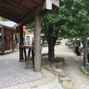 people sitting at tables under a tree
