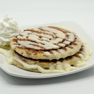 a plate of pancakes and whipped cream