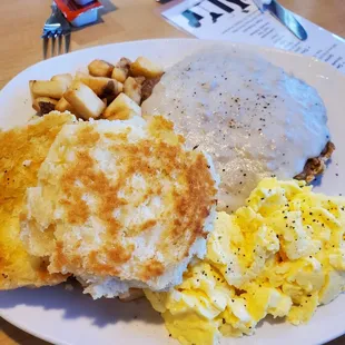 Chicken fried steak, eggs, country potatoes, and biscuit.