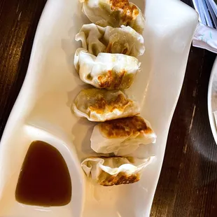 a plate of dumplings and sauce