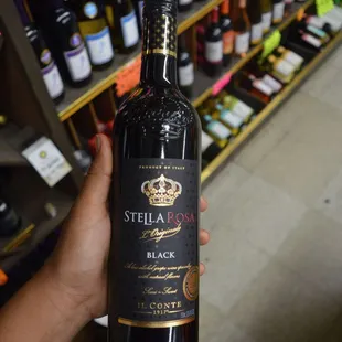a hand holding a bottle of wine