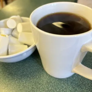 a cup of coffee and a bowl of marshmallows