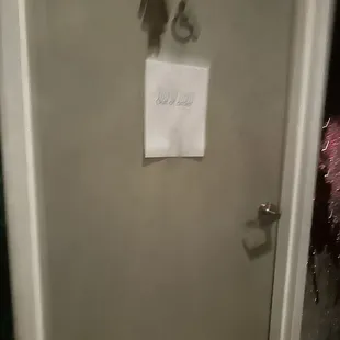 a bathroom door with a sign on it