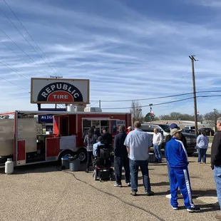 a group of people standing in front of a food truck