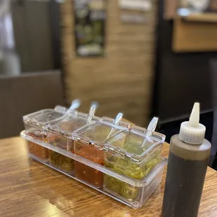a container of condiments and a bottle of condiments