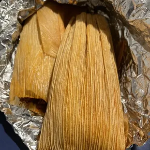 two tamales wrapped in foil