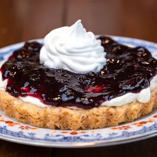 a blueberry cheesecake with whipped cream