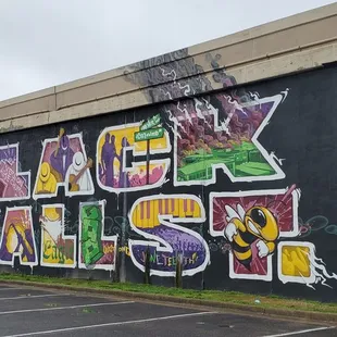 Mural on the freeway wall next to the Greenwood Community Center parking lot